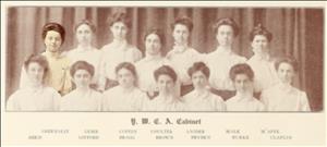 A yearbook photo of two rows of people. They are all blurred out except one smiling woman on the left. 